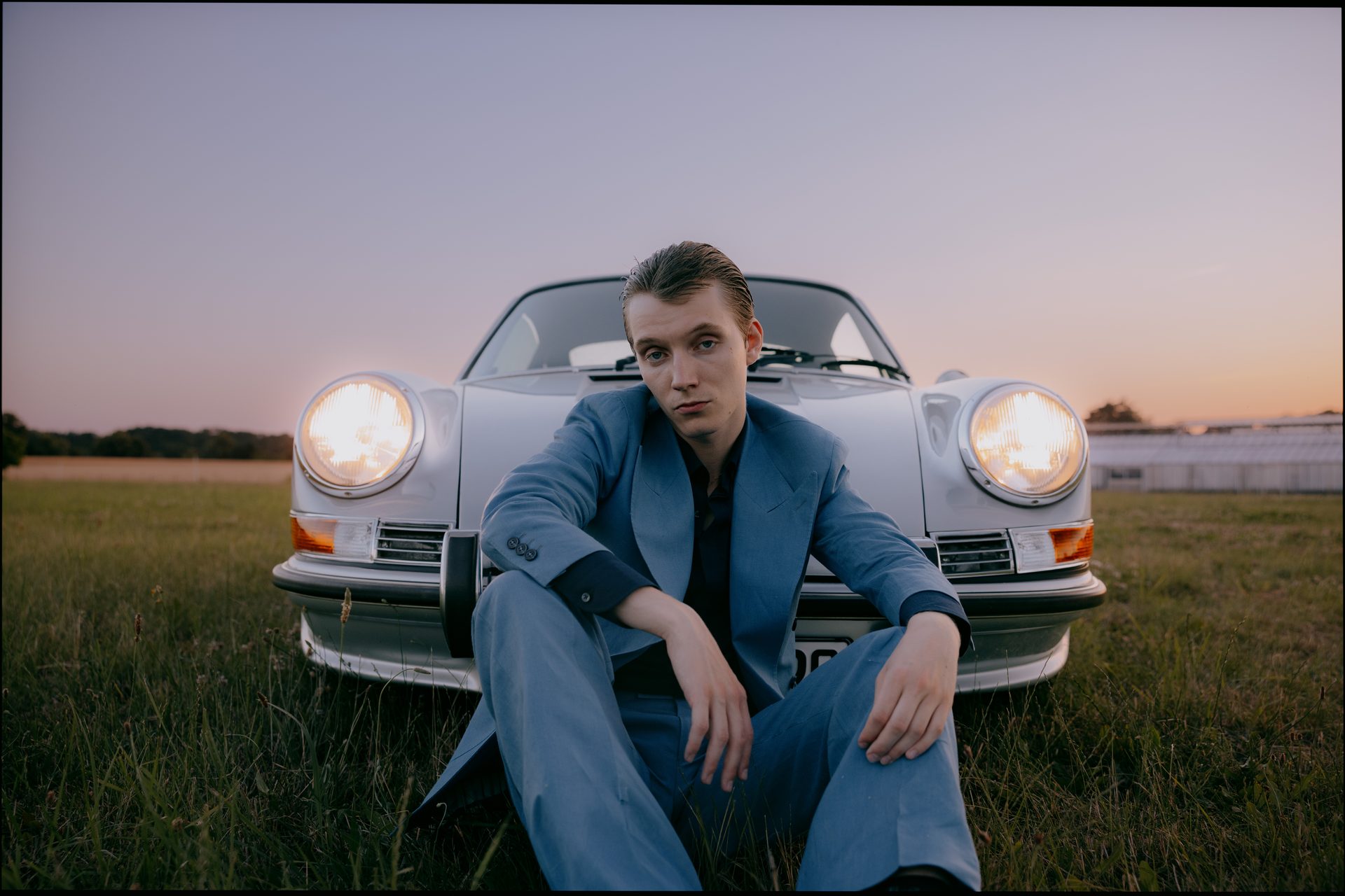 Maßkonfektion Editorial vor eingeschalteten Porsche Scheinwerfern